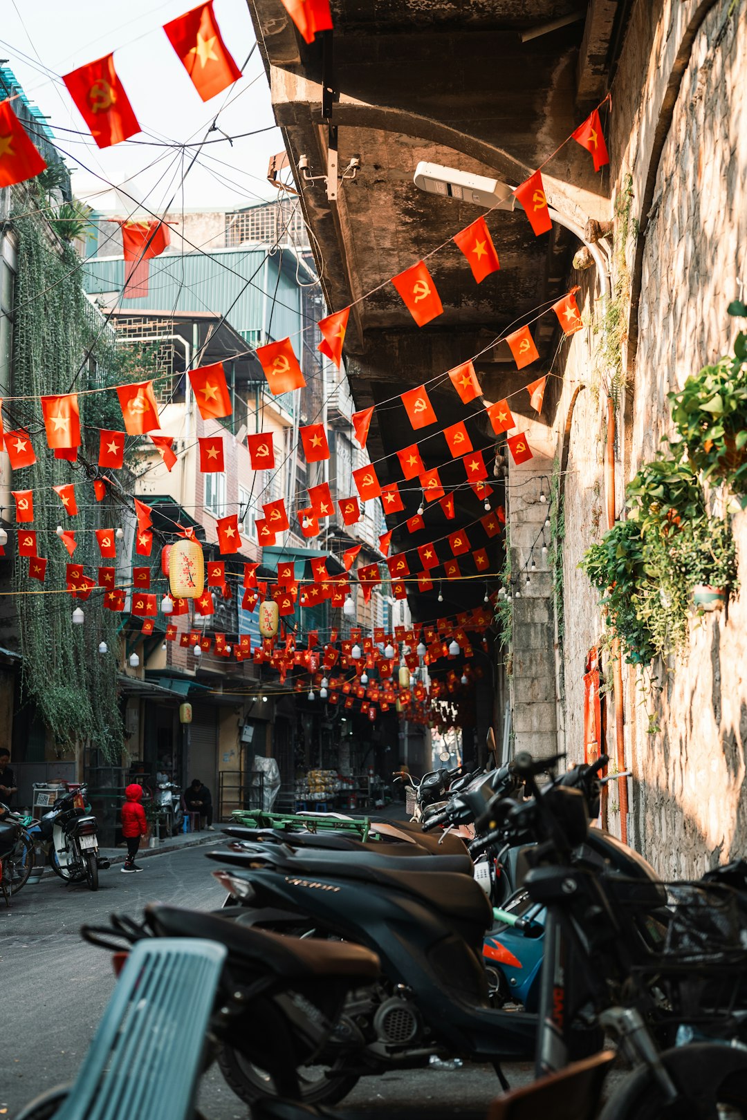 Hanoi Old Quarter street with Vietnamese flags and motorbikes