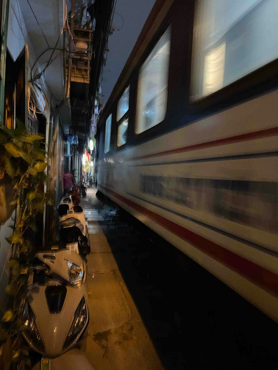 Train passing through Hanoi Train Street at night