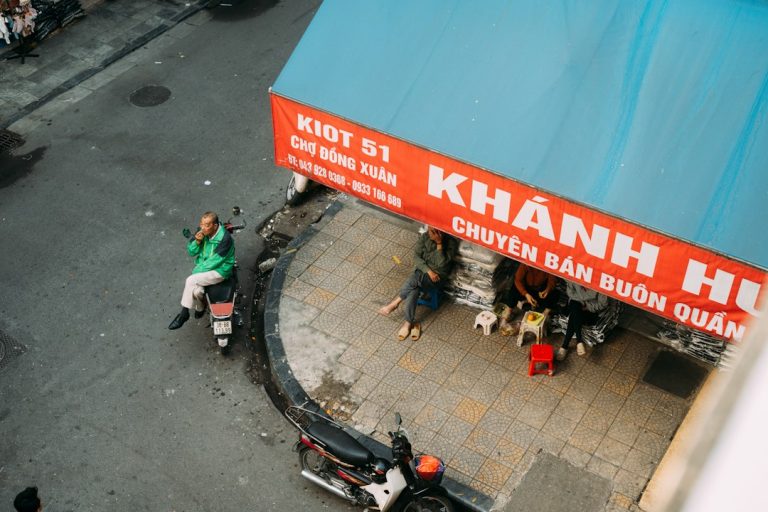 Dong Xuan Market area in Hanoi with street vendors and scooters