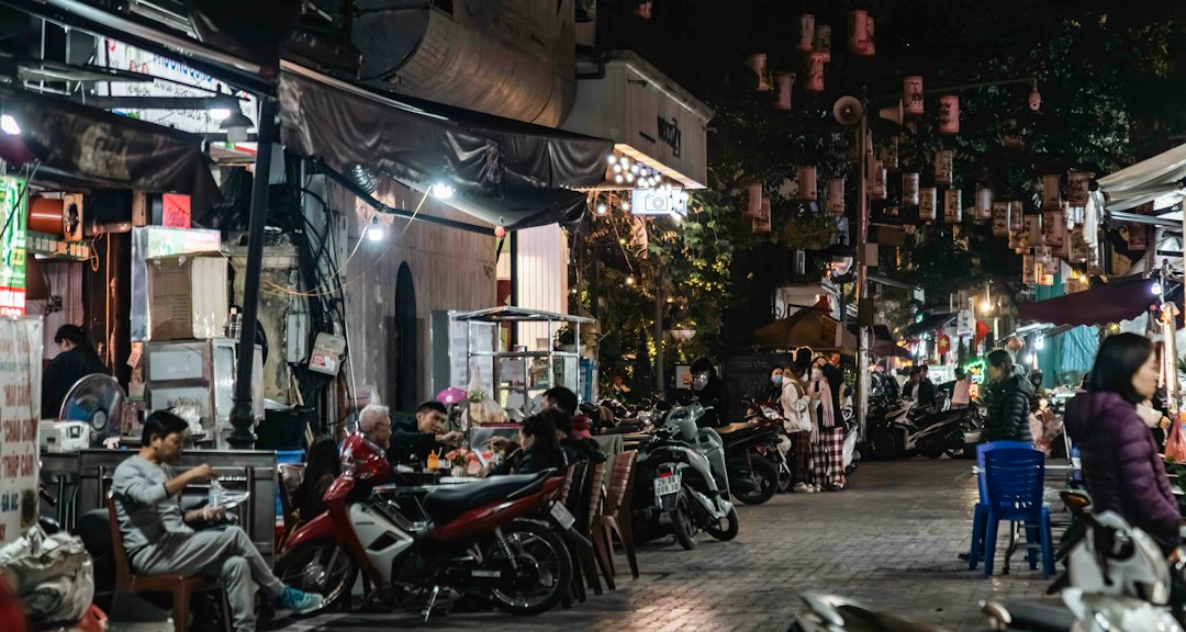 Hanoi night market street scene with people and motorbikes